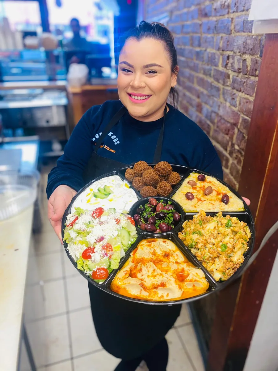 KOUS KOUS team member presenting a catering platter